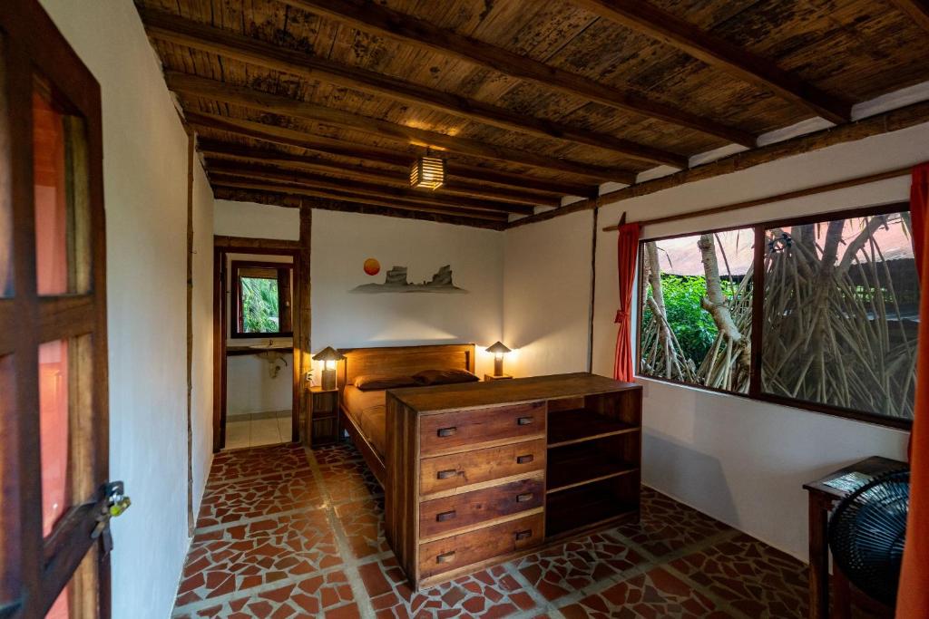 1 dormitorio con tocador de madera y ventana en Suites La Tortuga, en Ayampe