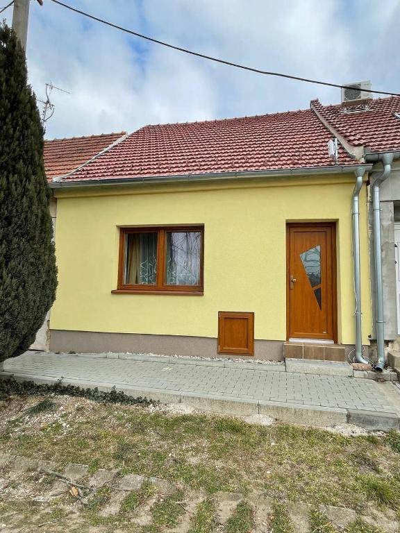żółty dom z brązowymi drzwiami i oknami w obiekcie Ubytování Valtík w mieście Valtice