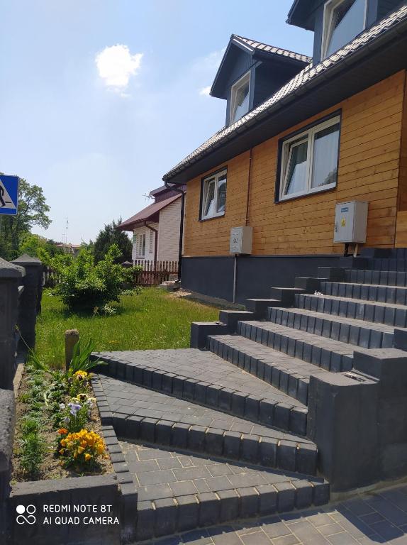 a house with stairs in front of a house at Domek przy parku in Susiec