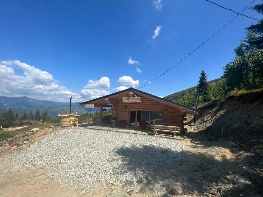 una pequeña cabaña con un banco delante en Cabana De Vis Pietrosul, en Borşa