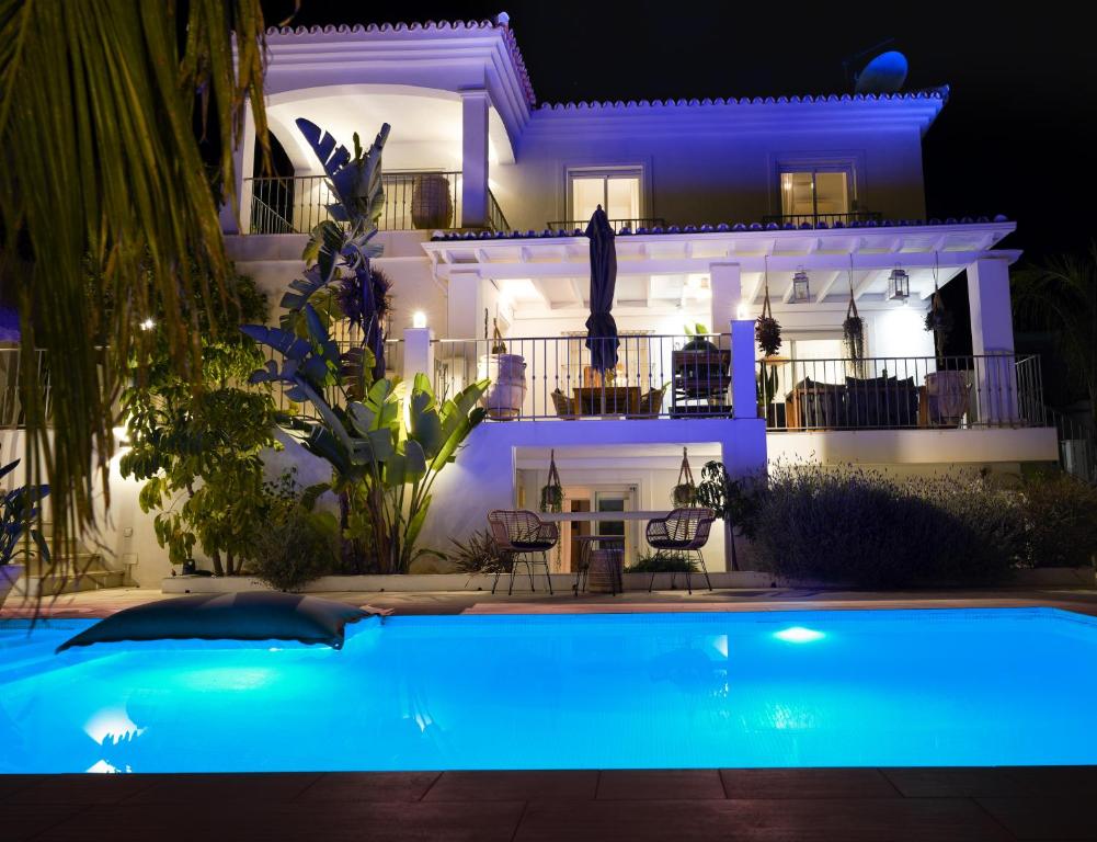 uma casa com piscina à noite em Thani Holidays em Coín