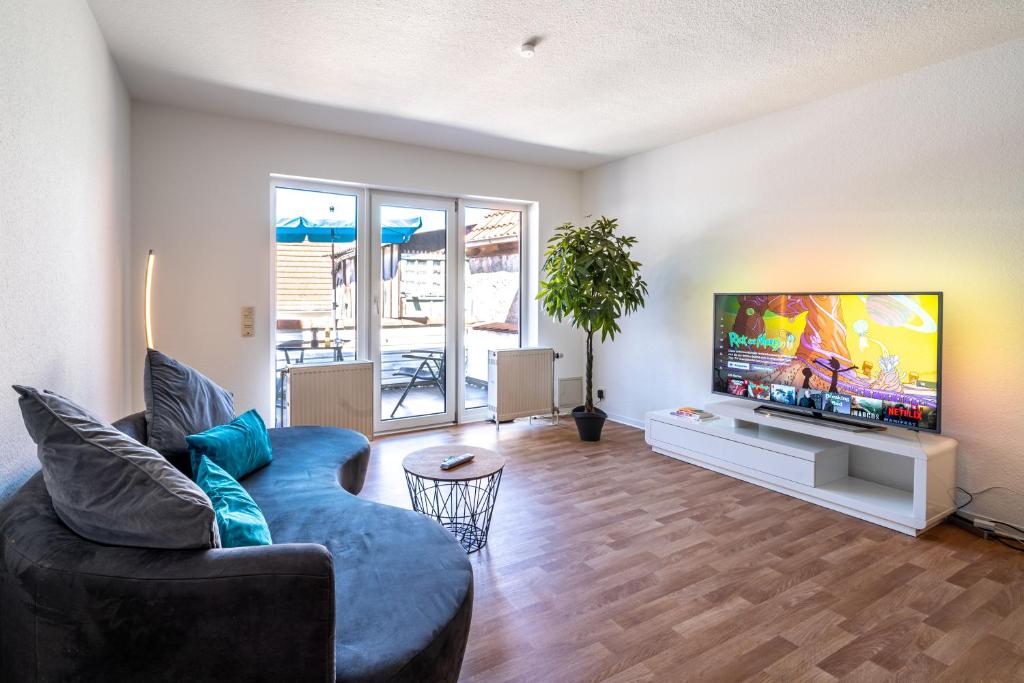 a living room with a couch and a flat screen tv at Stylische 2-Zimmer Wohnung - Balkon - Parkplatz - Smart TV - Arbeitsplatz in Friedberg