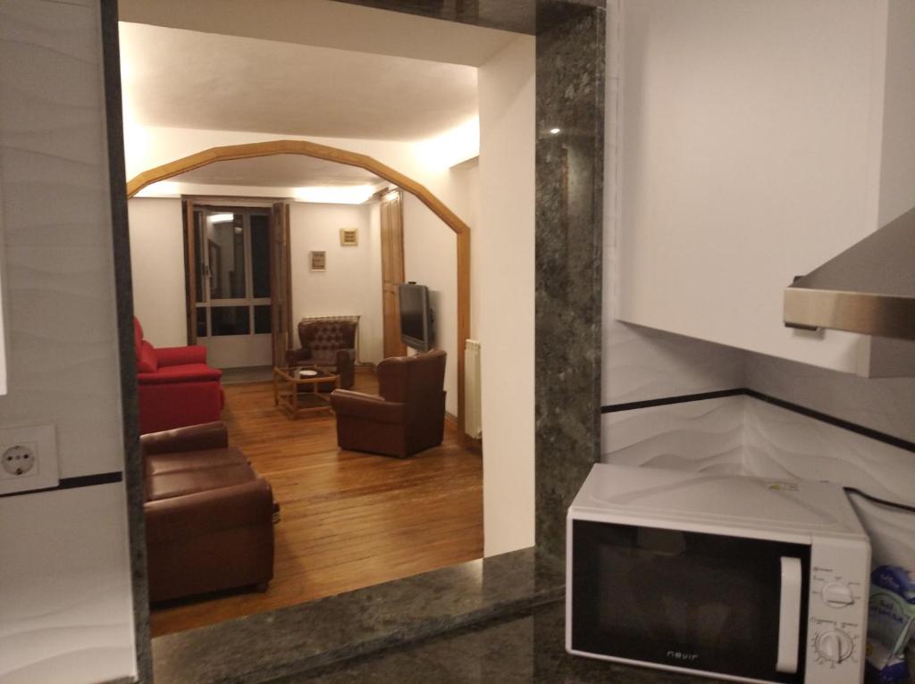 a view of a living room from a kitchen with a mirror at Vivienda A Travesía Dos Soños in Sarria