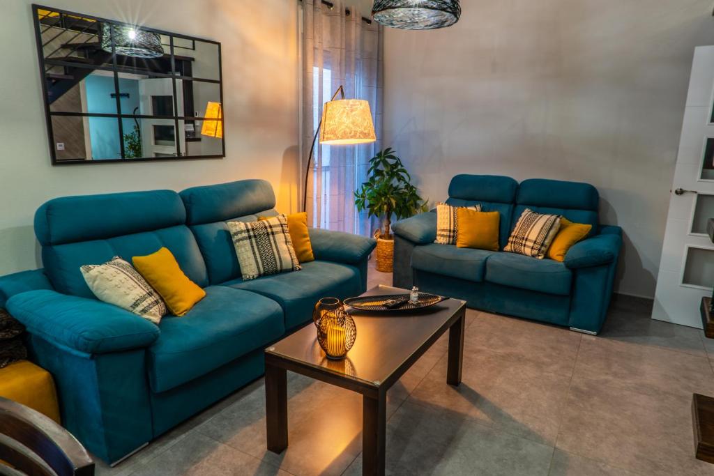 una sala de estar con 2 sofás azules y una mesa. en Apartamentos Turísticos El Altozano, en Fuentes de León