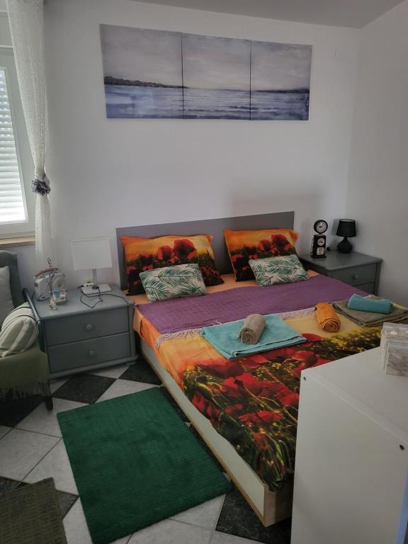 a bedroom with a bed and two tables with pillows at Studio Prommontore in Premantura