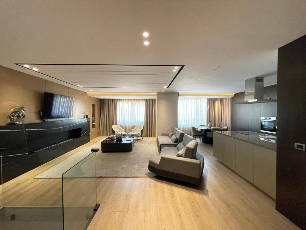 Luxury Lake View Duplex with Indoor Fireplace في شكودر: غرفة معيشة كبيرة مع أريكة ومطبخ