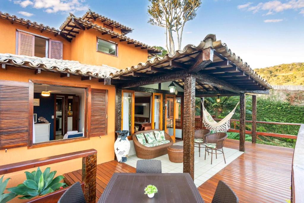 una terraza al aire libre con pérgola y muebles en Casa em Búzios com vista mar e piscina | EDF 12, en Búzios