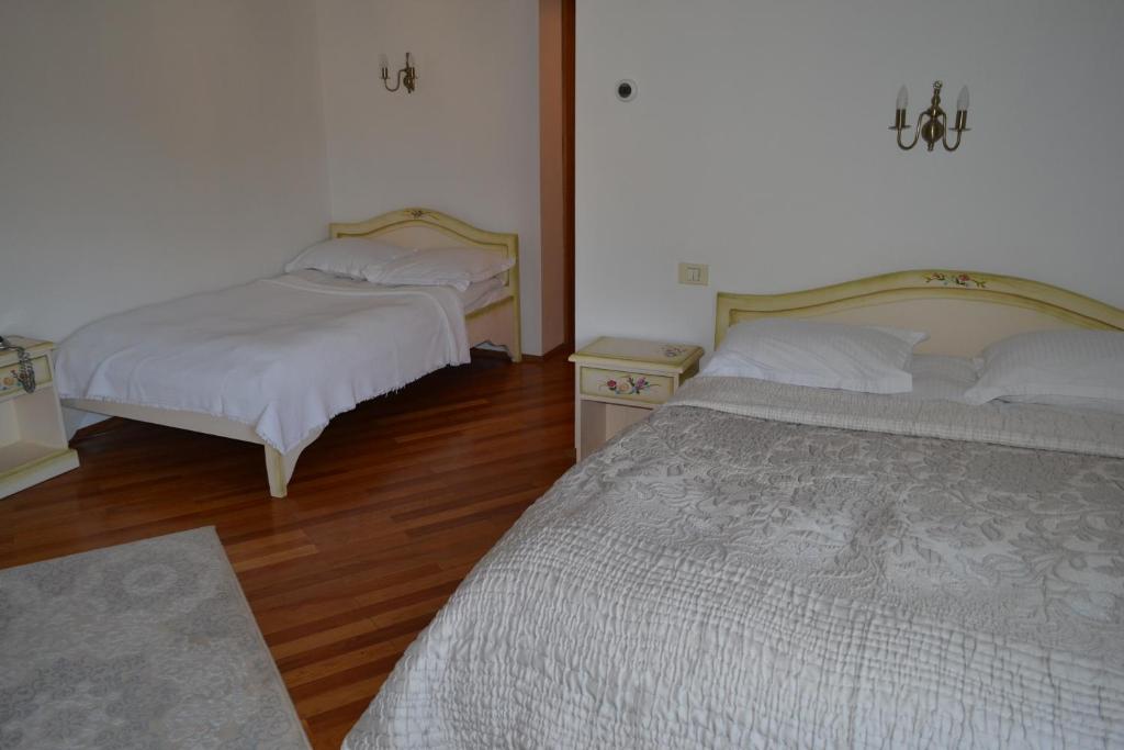 two beds in a room with wooden floors at Casa Cranta in Braşov