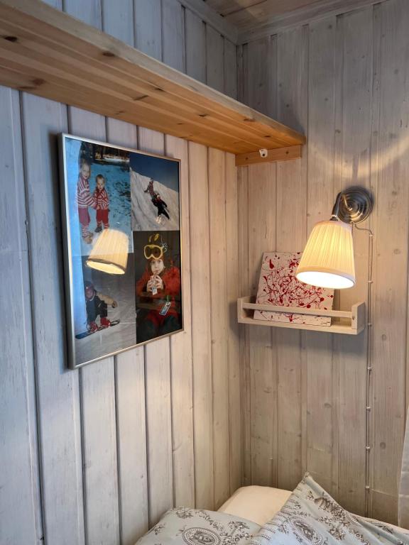 ein Schlafzimmer mit zwei Bildern an der Wand und zwei Lichtern in der Unterkunft Hjemmekoselig hytte med fantastisk utsikt in Beitostøl