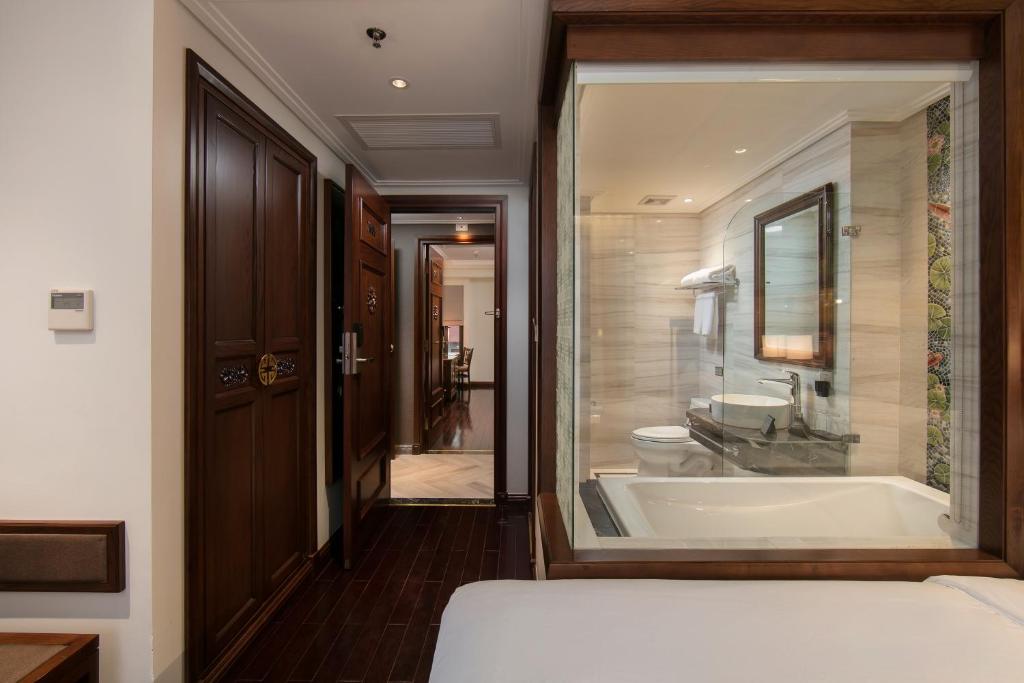 a bathroom with a tub and a toilet and a sink at Lucien Hanoi Lakeside Hotel & Rooftop in Hanoi