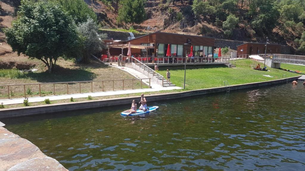two people on a paddle board in the water at Casa do Judas in Alvares