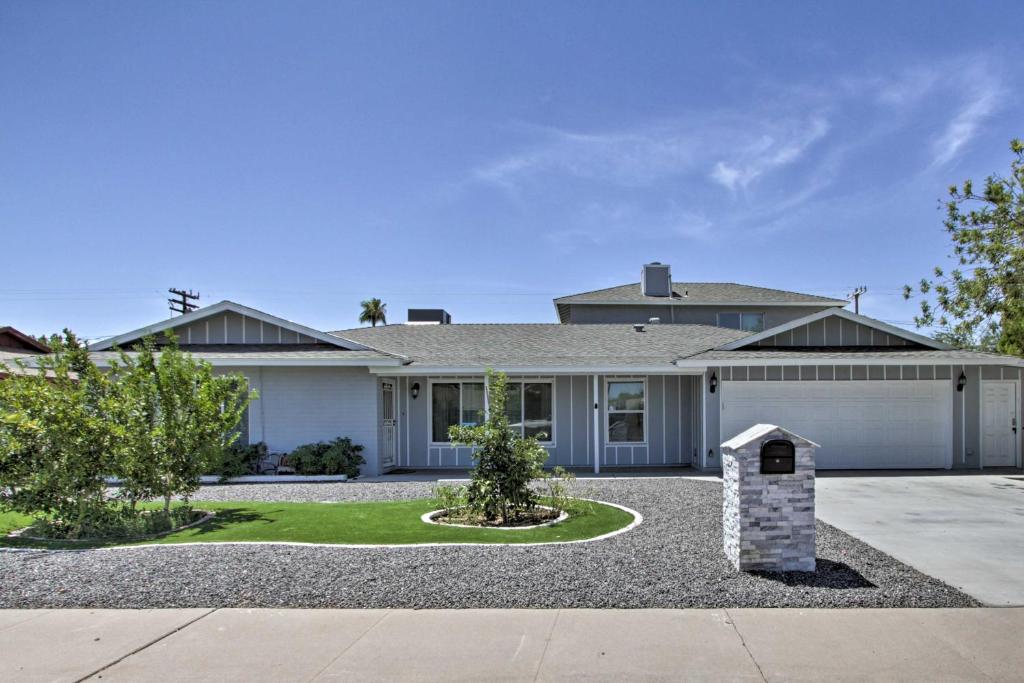 a large white house with a garage at Ultimate Phoenix Group Getaway Patio and Pool! in Phoenix