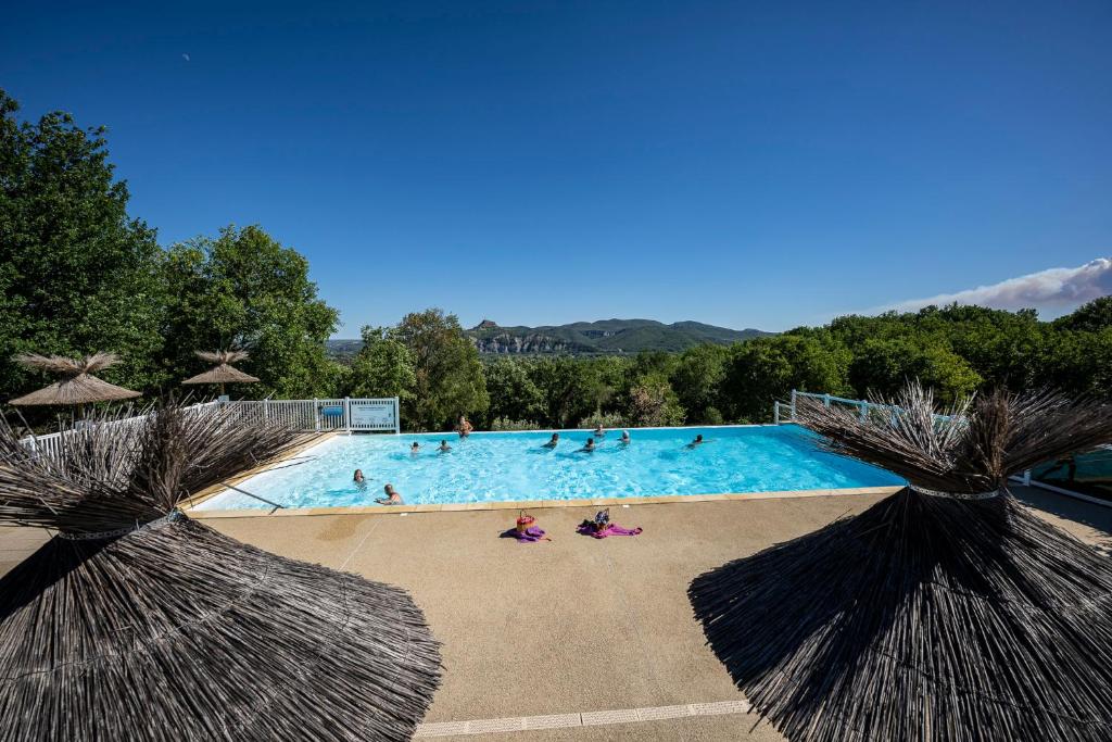 duży basen z osobami w nim w obiekcie Charmant camping Familiale 3 Etoiles vue 360 plage piscine à débordement empl XXL w mieście Labeaume