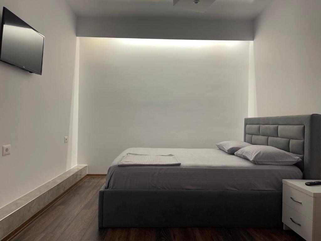 a bedroom with a bed and a tv on the wall at Apartament The City Block in Pogradec