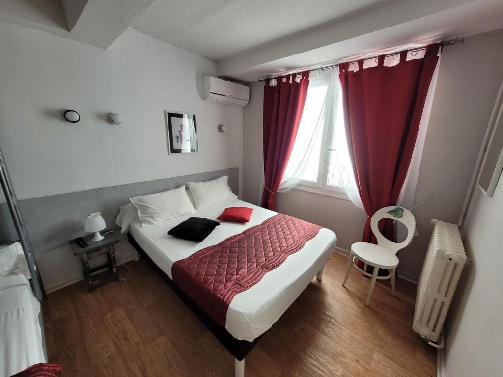 a bedroom with a large bed and a window at Le Cérétan Hôtel in Céret