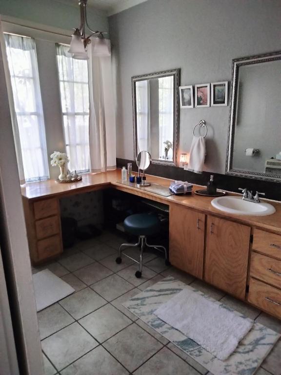 拉斯頓的住宿－Restful，一间带水槽的浴室和一张带镜子的书桌