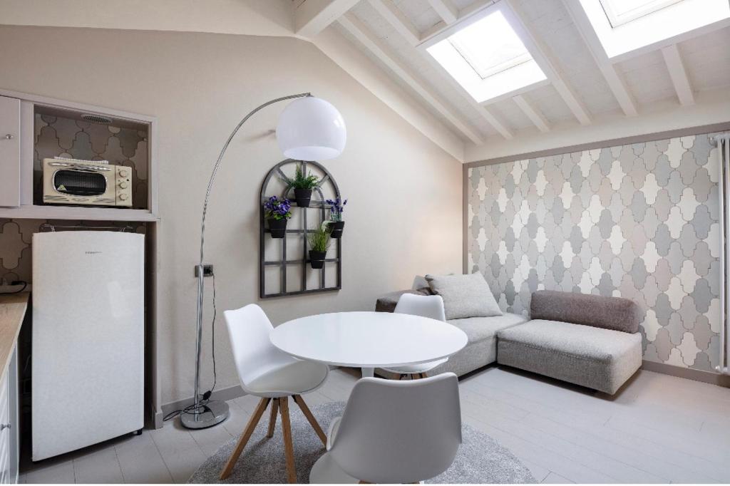 ein Wohnzimmer mit einem weißen Tisch und einem Sofa in der Unterkunft Maison del Ducato “Cavour 24” in Parma