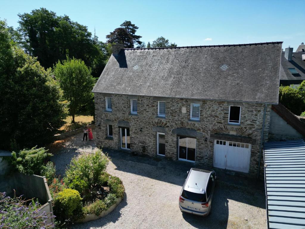 an old stone house with a car parked in front at La Demeure de Cathy in Agneaux