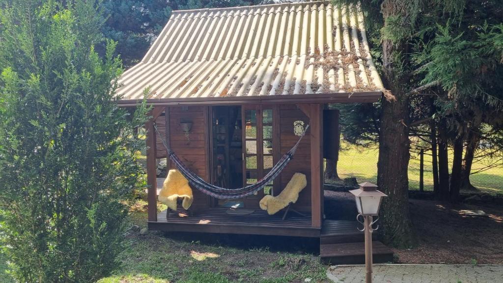 Una pequeña casa en el árbol con una hamaca. en Chalé Rural em Canela, en Canela