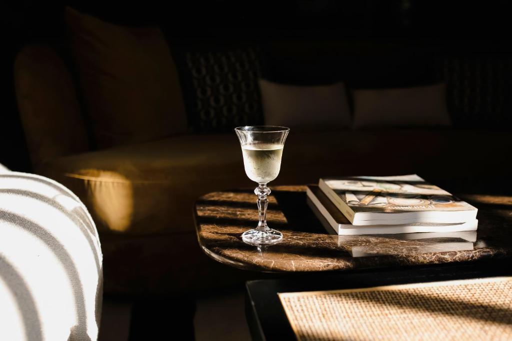 a glass of wine sitting on a table with books at Backstage Hotel - an Atlas Boutique Hotel in Tel Aviv