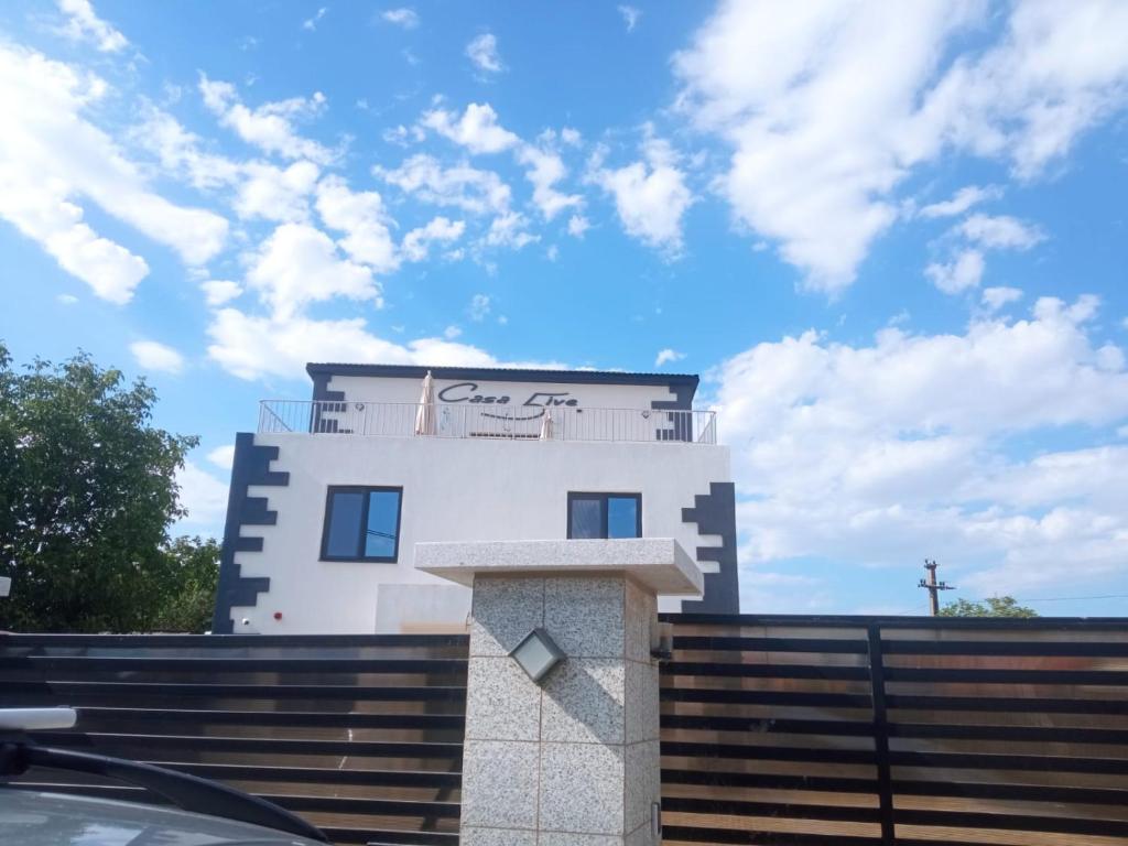 a white building with a cross on top of it at Casa 5ive in Tăşnad