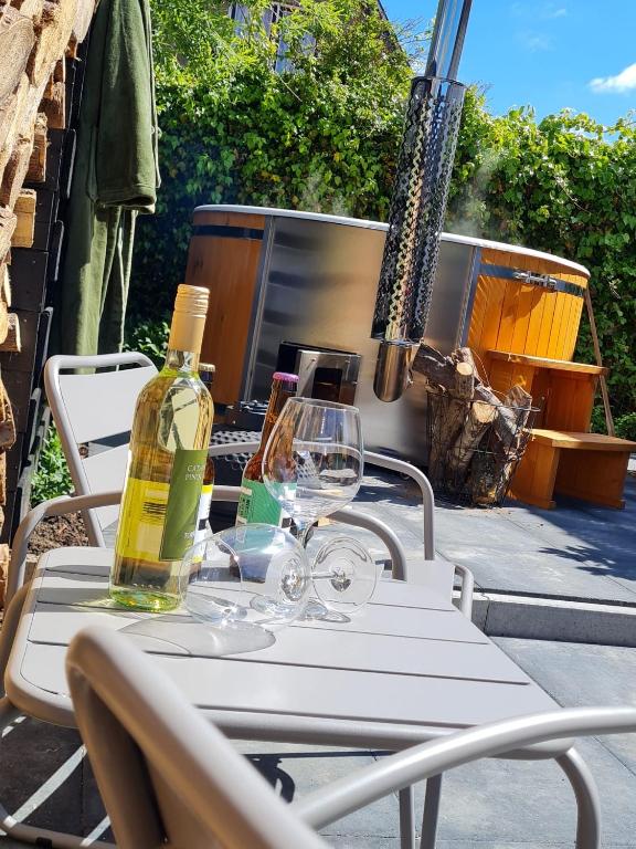 a white table with two bottles and glasses on it at Ambiance in Hollum