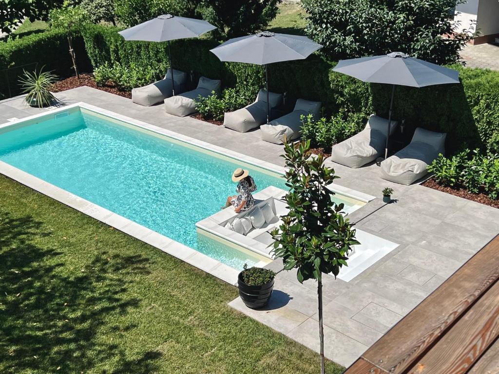 an overhead view of a swimming pool with chairs and umbrellas at Villa Pomona in Bled