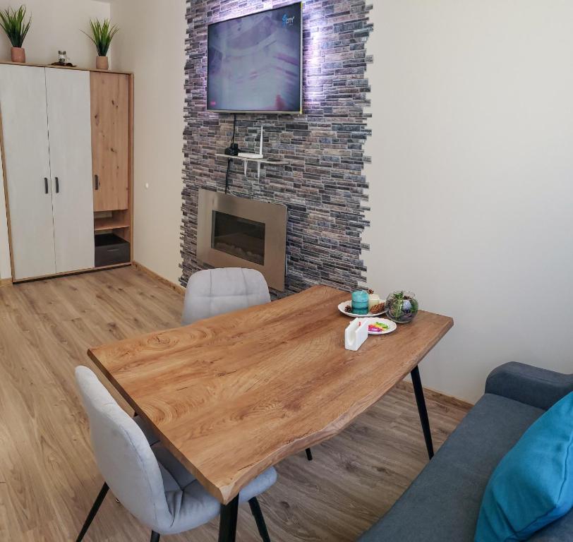 uma sala de estar com uma mesa de madeira e uma lareira em KLEPALSKI - Mountain Studio em Borovets