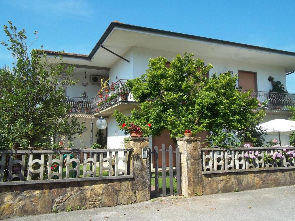 una casa blanca con una valla y árboles en Appartamento da Benito & Renza, en Lucca