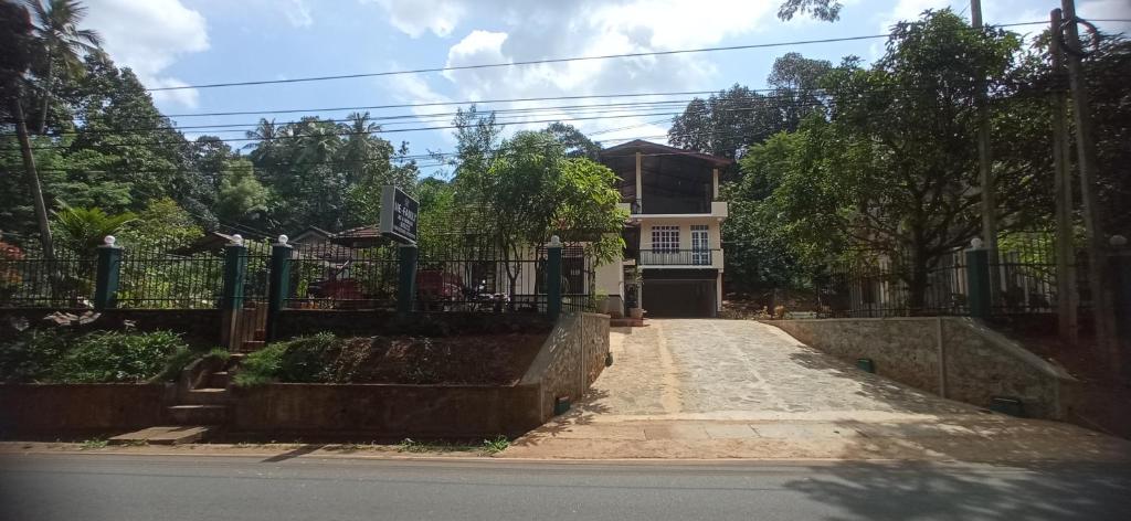 une maison avec une clôture sur le côté d'une rue dans l'établissement Me-Family, à Matale