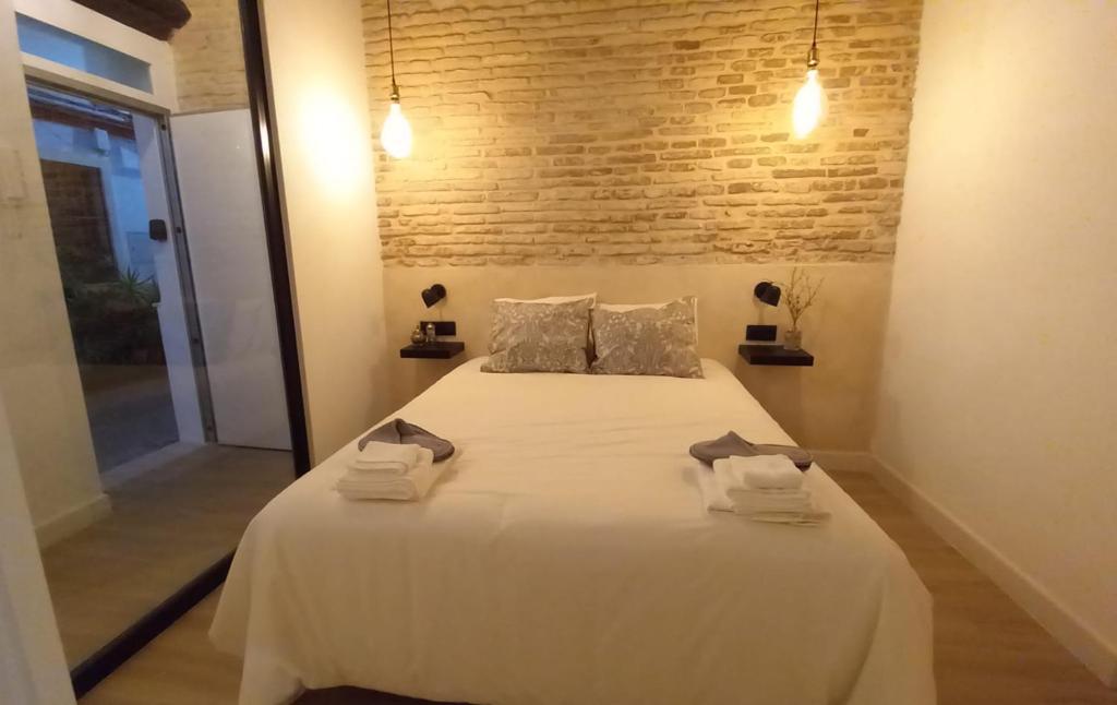 a bedroom with a large white bed with towels on it at Carmona&House in Seville