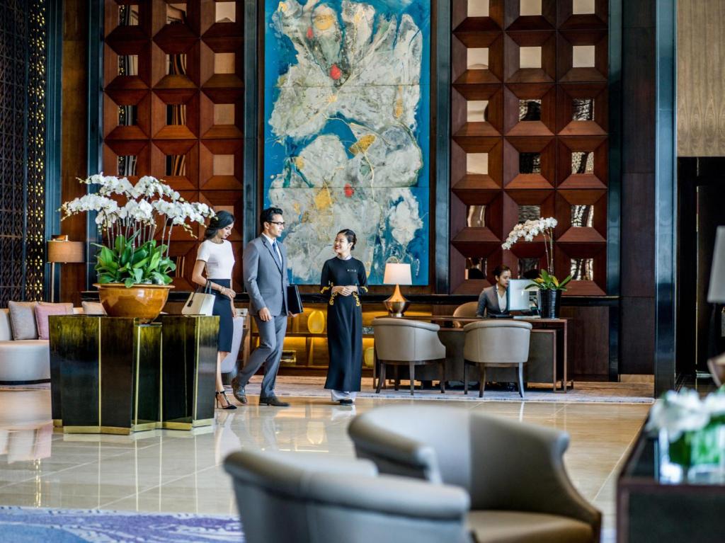 a group of people standing in a lobby at InterContinental Hanoi Landmark72 by IHG in Hanoi