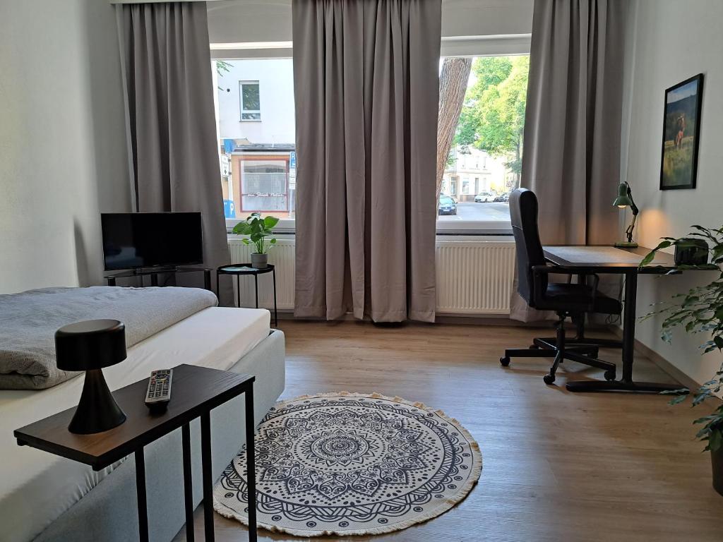 a living room with a bed and a desk with a computer at Waldstadt-Apartments in Iserlohn