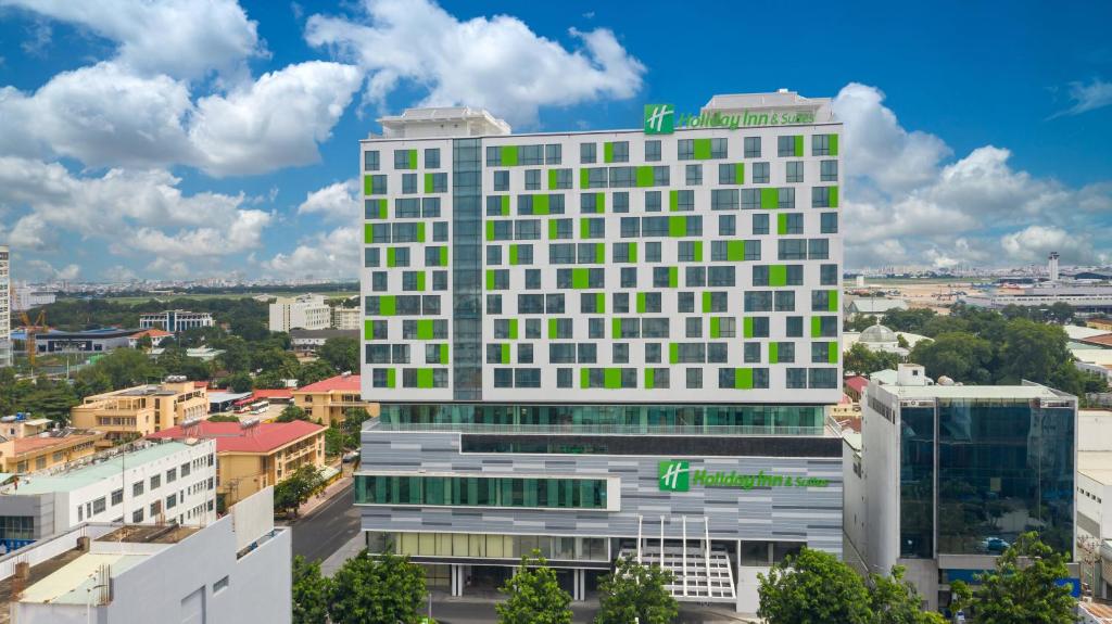 胡志明市的住宿－Holiday Inn & Suites Saigon Airport, an IHG Hotel，一座高大的白色建筑,设有绿色的窗户