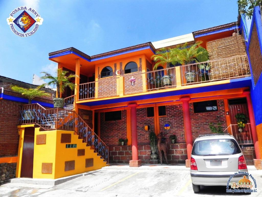 a colorful house with a car parked in front at Posada Arny in Tepotzotlán