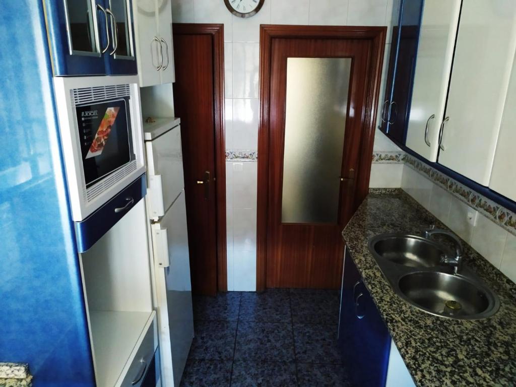 a small kitchen with a sink and a microwave at Apartamento Valle del Medio in San Vicente de Alcántara