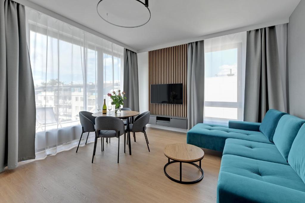 salon z niebieską kanapą i stołem w obiekcie Baltic Lagoon - Okrzei Residence w mieście Sopot