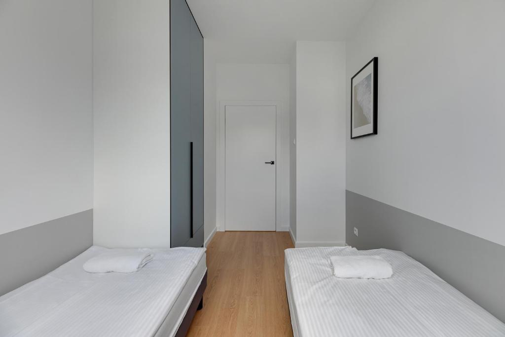 Łóżko lub łóżka w pokoju w obiekcie Baltic Lagoon - Okrzei Residence
