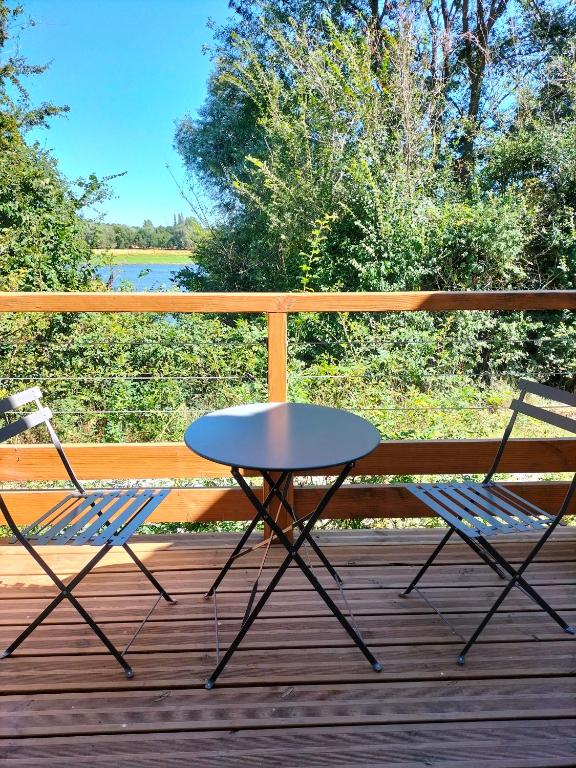 2 chaises et une table sur une terrasse dans l'établissement Maison bord de Loire, à Rochefort-sur-Loire