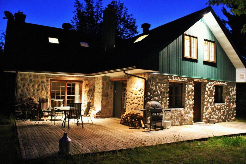 a house with a wooden deck in front of it at Chalet Rustique CRDS Tremblant in Lac-Superieur