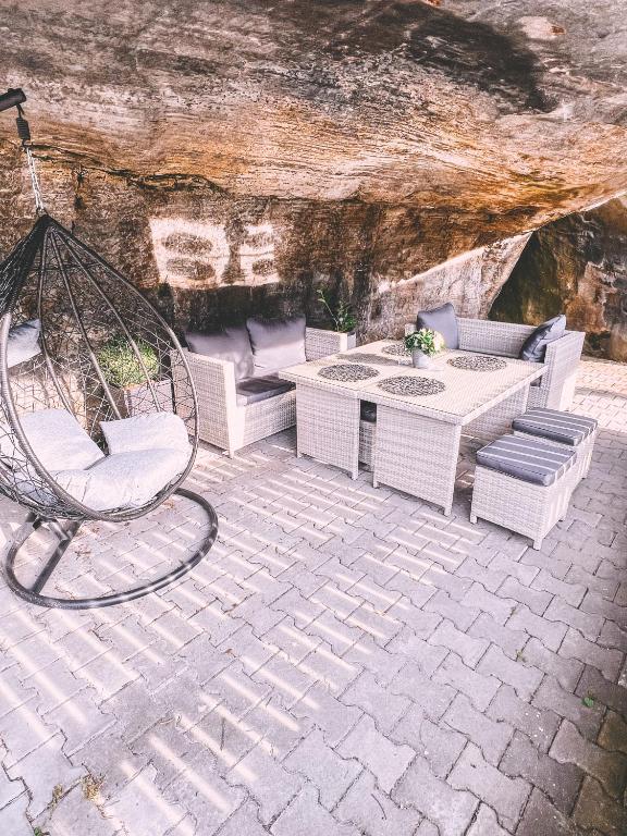 a patio with a swing and a table and chairs at Unicorn Hřensko in Hřensko