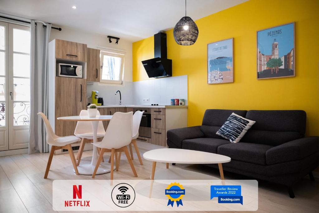 een woonkamer met een bank en een tafel bij ColorPop - Netflix Wifi Tout équipé - Appart Pézenas Centre in Pézenas