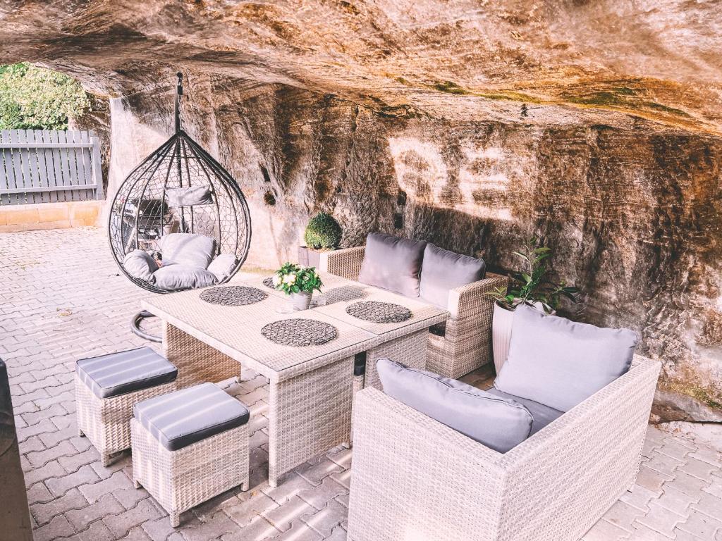 a patio with a table and chairs and a swing at Unicorn Hřensko in Hřensko