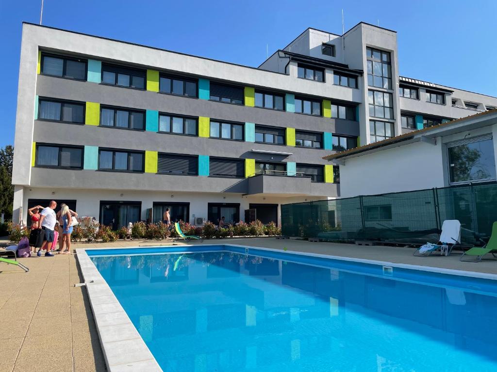 hotel z basenem przed budynkiem w obiekcie Lila Apartman w Balatonföldvárze