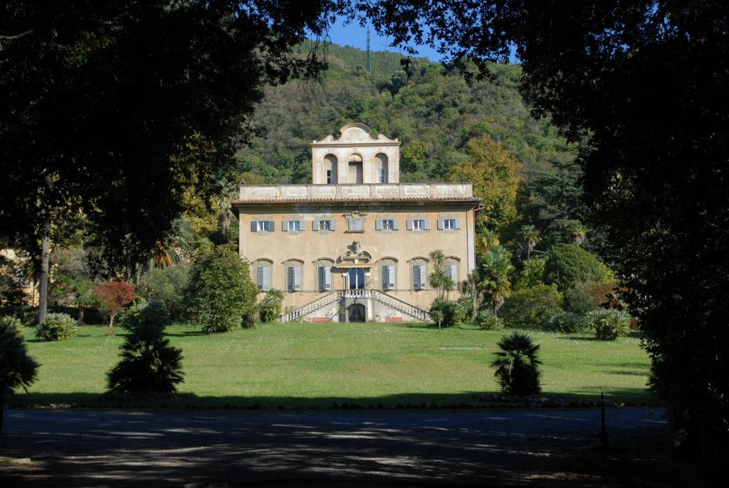 a large building with a clock on the front of it at Villa di Corliano Relais all'Ussero in San Giuliano Terme