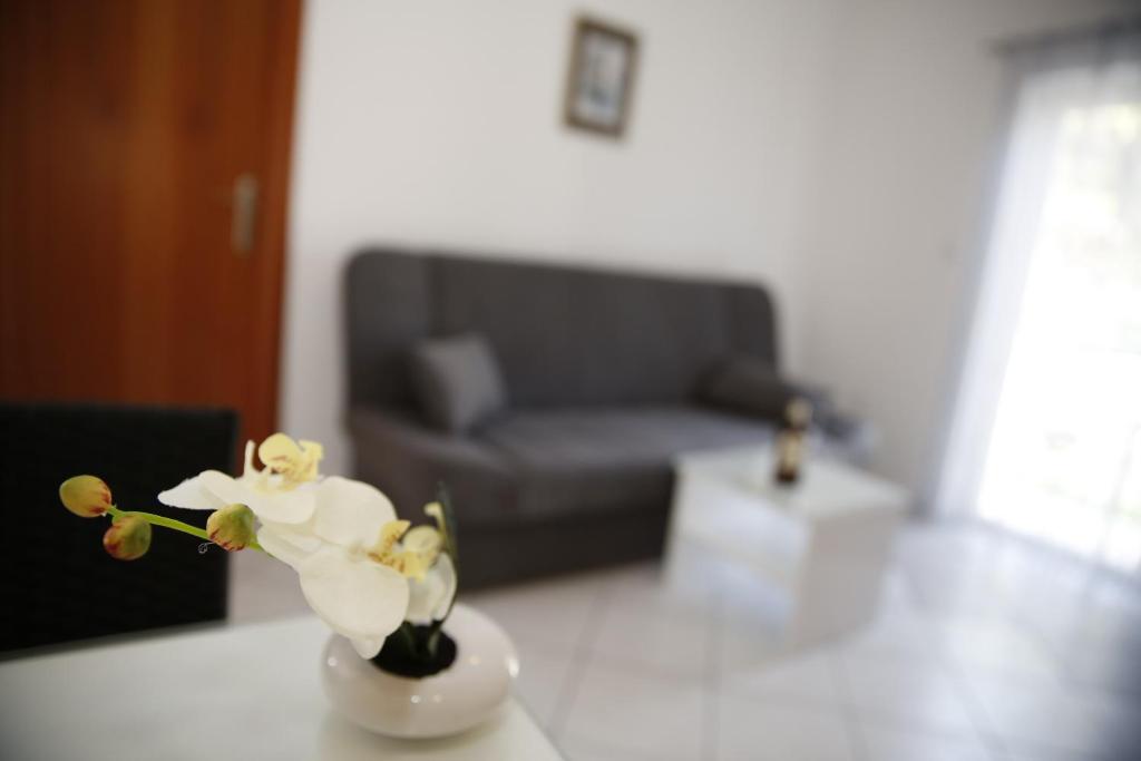 a vase with a flower on a table in a living room at Apartments Lepur in Vodice