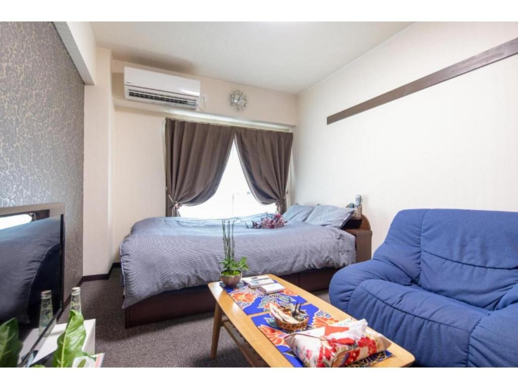 京都市にあるcozy house - Vacation STAY 13159のベッド、ソファ、テーブルが備わる客室です。