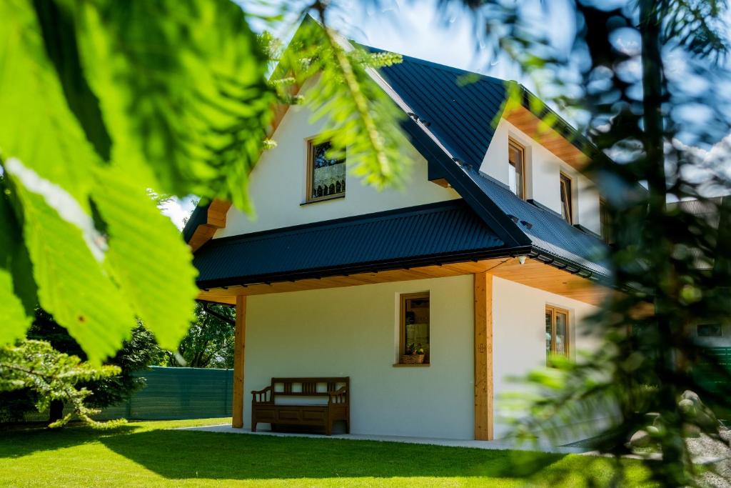 a house with a blue roof with a yard at Domek Przekolec in Szaflary