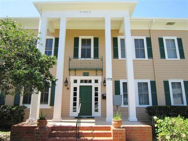 a large house with a green door and white columns at Cozy & Quiet Two Bedroom Condo In The Heart Of Historic St. Augustine in Saint Augustine
