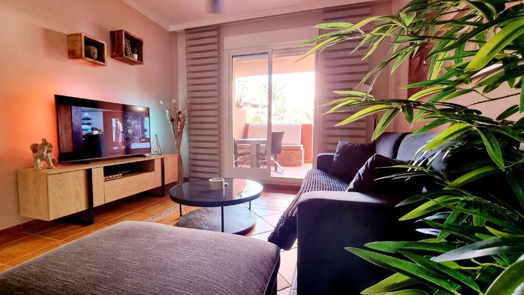 a living room with a couch and a tv at Villas de Almerimar Golf in El Ejido